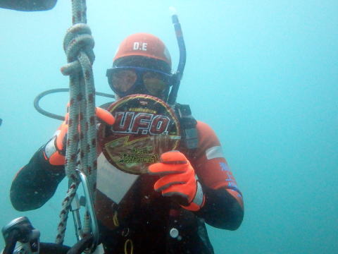 水中でカップラーメンをもつ潜水士
